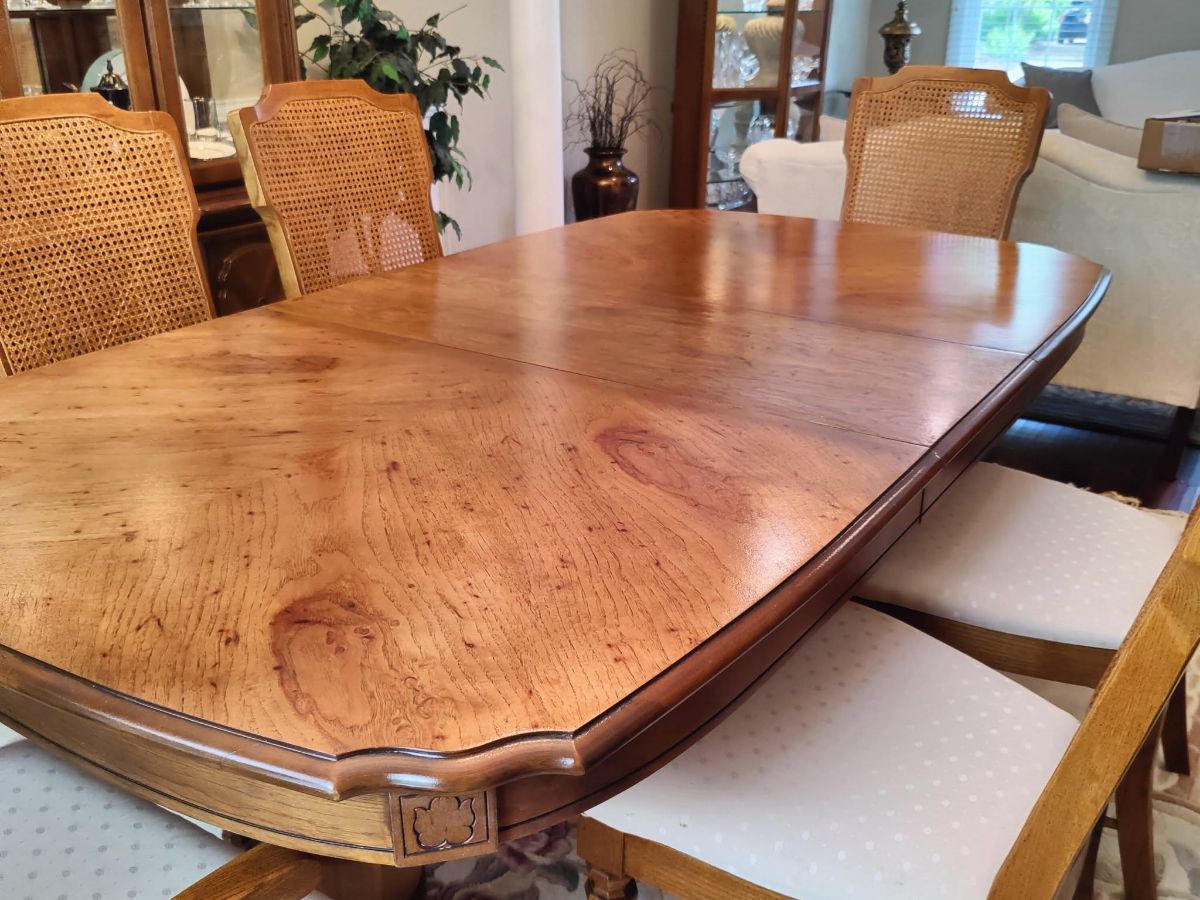 A refinished dining table with cane-backed chairs, back in the customer's dining room.