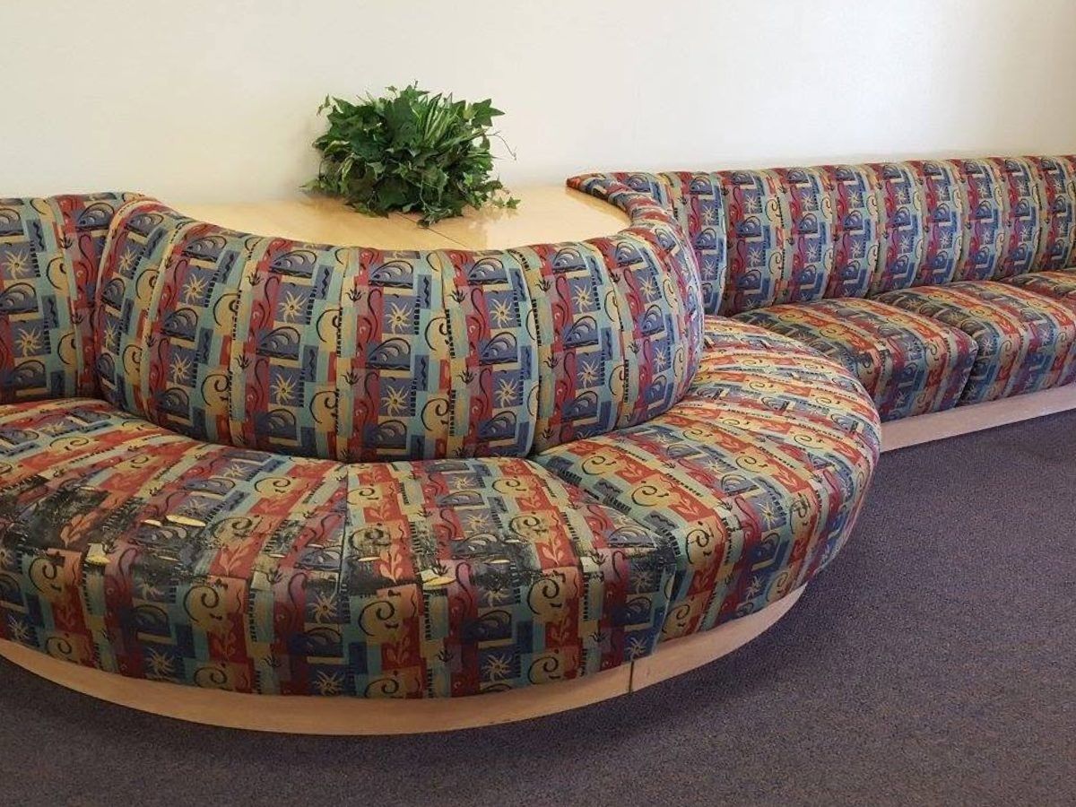 A curved banquette seat in a hotel lobby, reupholstered in a bold patterned contract fabric.